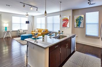 A modern kitchen with a large island and a dining area.